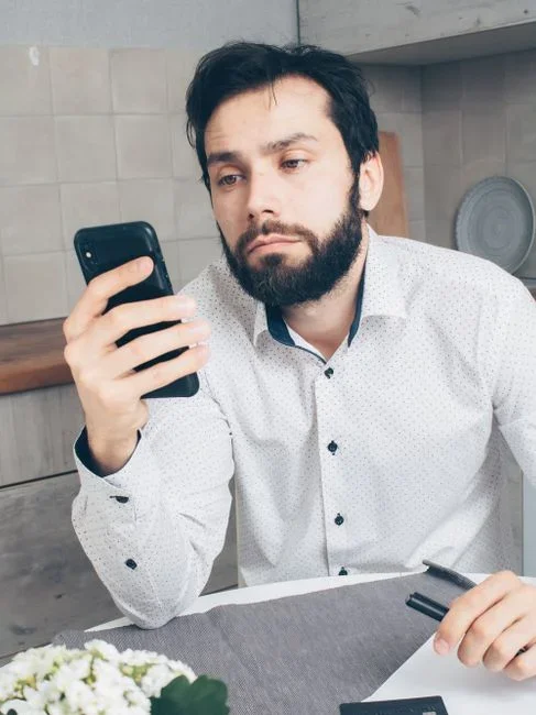 A person looking confused at a smartphone full of pop-up windows