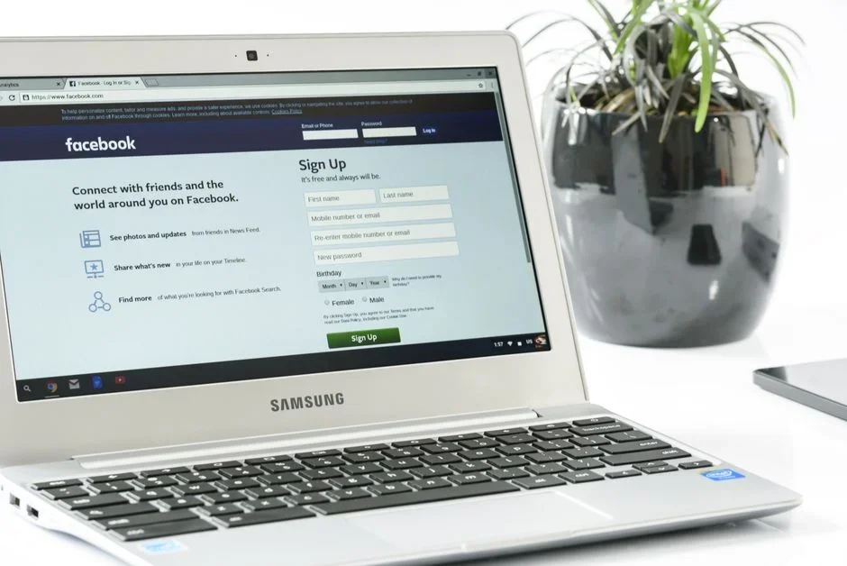 Magnifying glass over a laptop screen showing company and team profiles